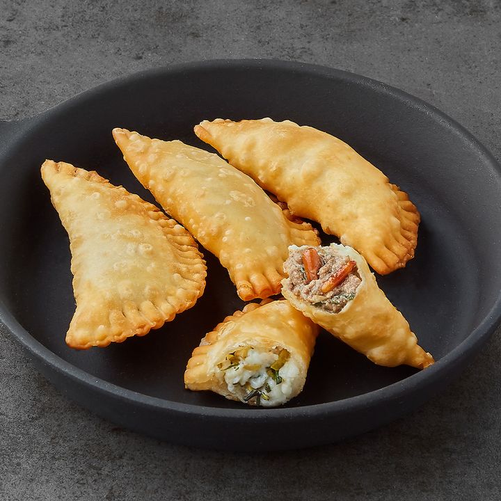 Plate of crispy fried pastries filled with meat and with cheese