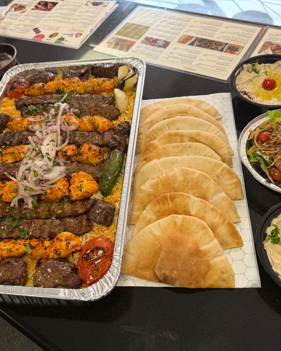 Mixed grill tray with kebabs, rice, pita, hummus and salad