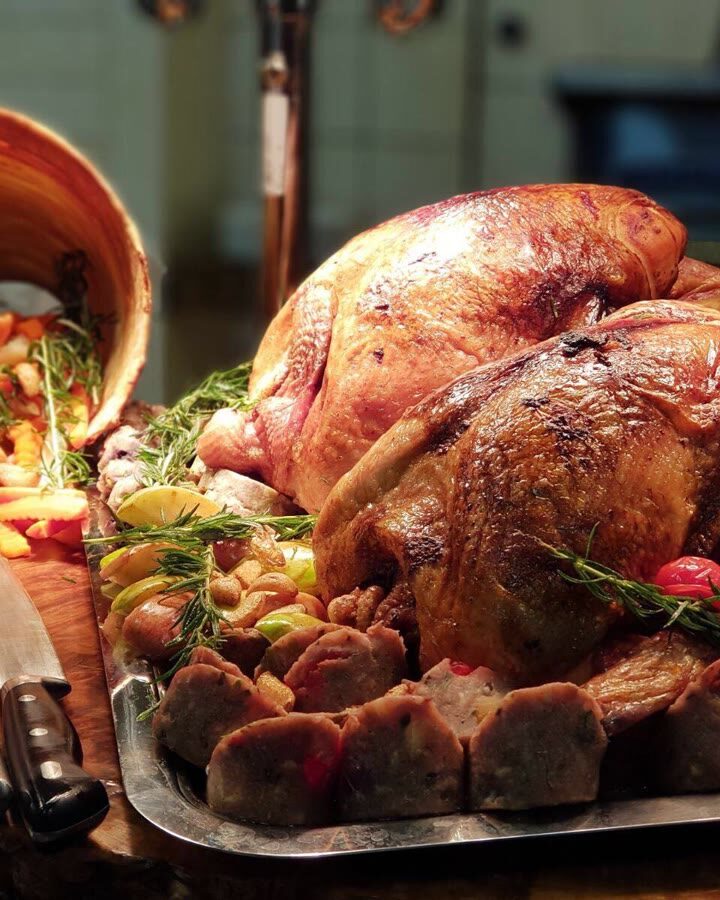 Roast turkey on a tray with rosemary and vegetables