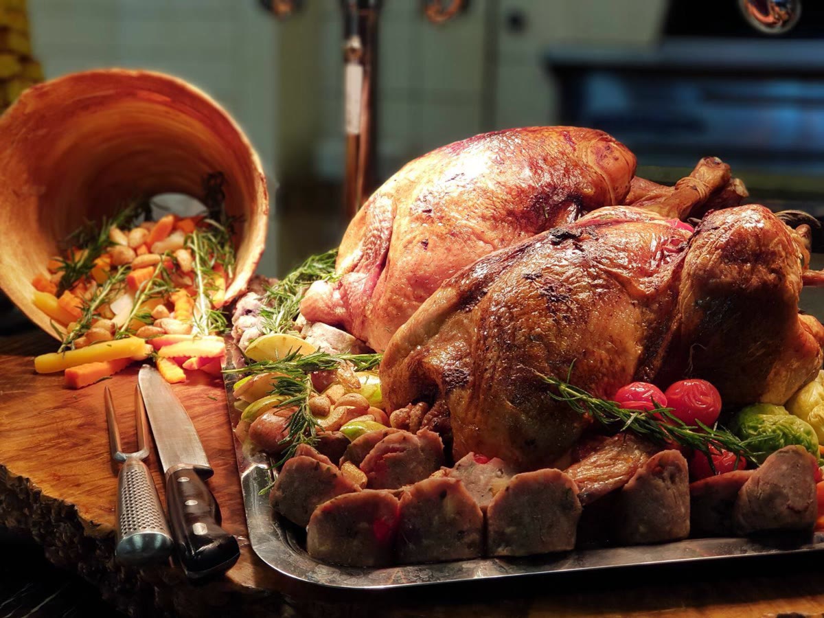 Roast turkey on a tray with rosemary and vegetables